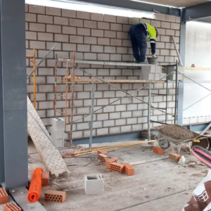 trabajador-de-aroalan-realizando-reforma-de-fachada-de-ladrillo-cara-vista-en-obra-nueva-madrid-españa